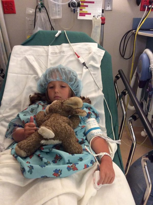 little girl in hospital bed with bunny